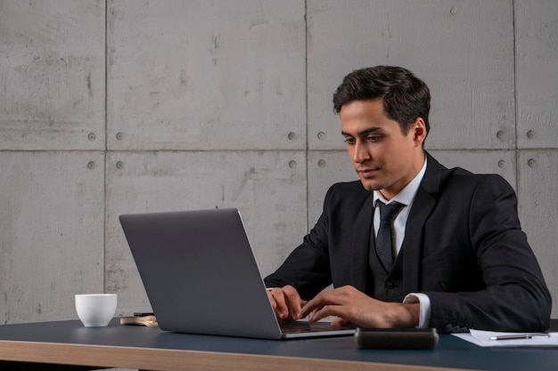 Giovane uomo d'affari centrato che utilizza il computer portatile in ufficio