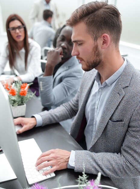 Giovane uomo d'affari che utilizza un computer sul posto di lavoro persone e tecnologia