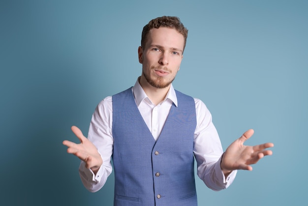 Giovane uomo d'affari con la barba su sfondo blu isolato che gesturing