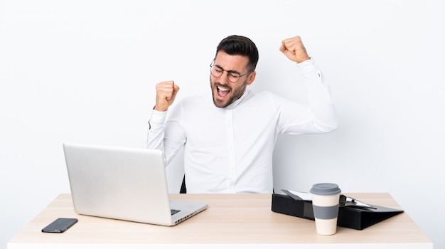 Giovane uomo d'affari in un posto di lavoro che celebra una vittoria