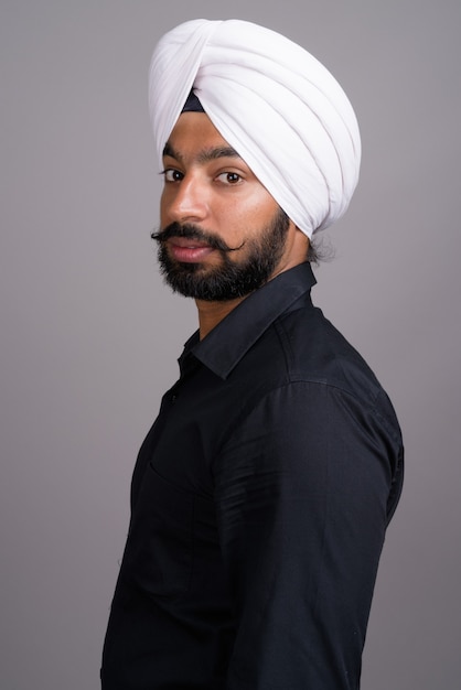 Giovane uomo d'affari indiano Sikh che indossa turbante bianco