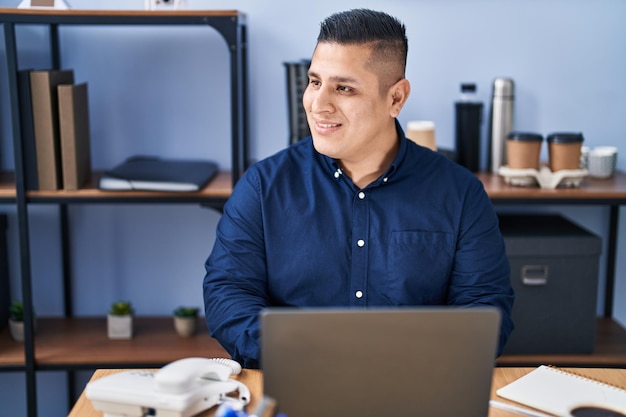 Giovane uomo d'affari latino che utilizza il computer portatile che lavora all'ufficio