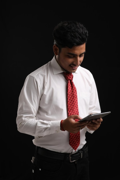 Giovane uomo d'affari o impiegato indiano che utilizza smartphone