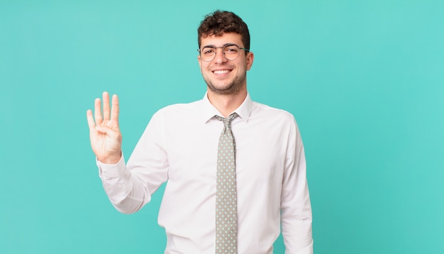 Giovane uomo d'affari sorridente e dall'aspetto amichevole, mostrando il numero quattro o il quarto con la mano in avanti, conto alla rovescia