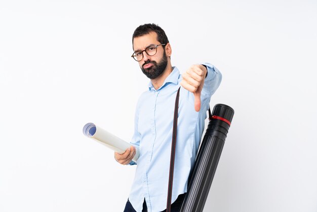 Giovane uomo dell'architetto con la barba sopra la parete bianca isolata che mostra pollice giù con l'espressione negativa