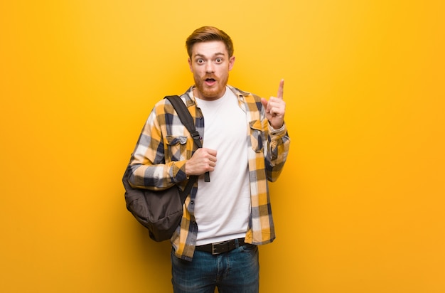 Giovane uomo dello studente di redhead che ha un'idea