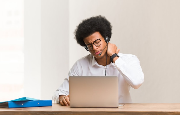 Giovane uomo di colore telemarketer che soffre di dolore al collo