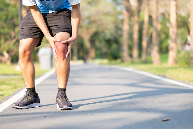 Giovane uomo di forma fisica che tiene la sua ferita della gamba di sport. muscolo doloroso durante l&#39;allenamento