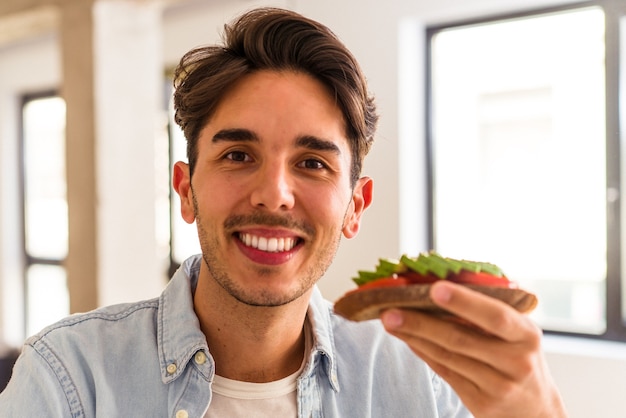 Giovane uomo di razza mista che fa colazione nella sua cucina