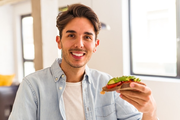 Giovane uomo di razza mista che fa colazione nella sua cucina