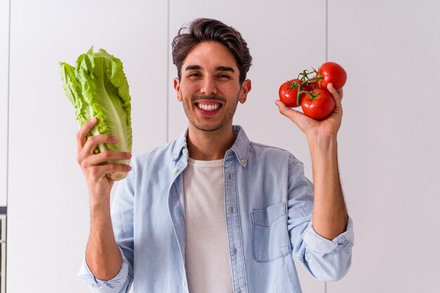 Giovane uomo di razza mista che prepara un'insalata per pranzo