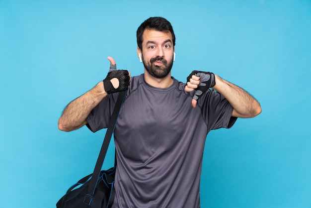 Giovane uomo di sport con la barba sopra il segno buono-cattivo di fabbricazione blu isolato. Indeciso tra sì o no