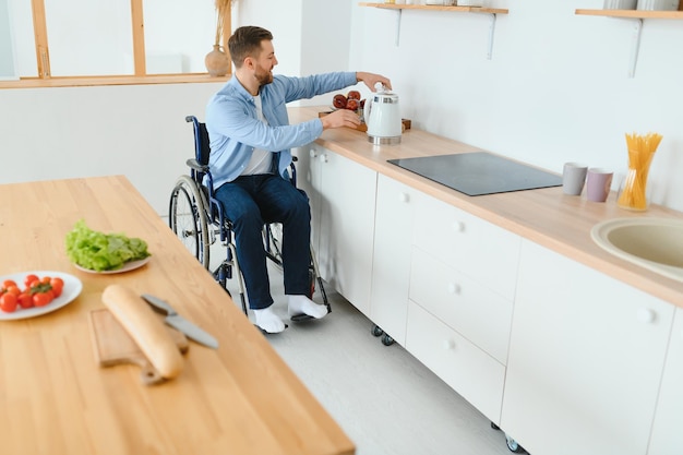 Giovane Uomo Disabile Sulla Sedia A Rotelle In Cucina