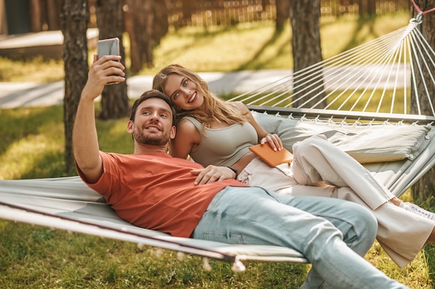 Giovane uomo e donna allegri che prendono selfie