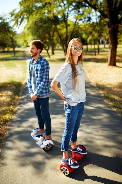 Giovane uomo e donna che cavalcano l'Hoverboard nelle tecnologie dei contenuti del parco un nuovo movimento