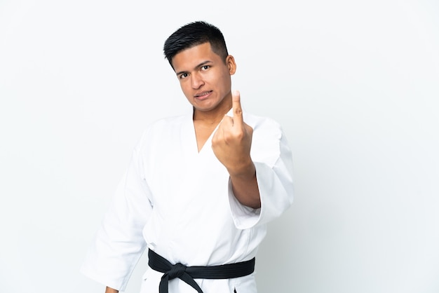 Giovane uomo ecuadoriano facendo karate isolati su sfondo bianco facendo gesto in arrivo