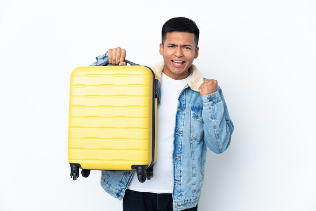 Giovane uomo ecuadoriano isolato su sfondo bianco in vacanza con valigia da viaggio