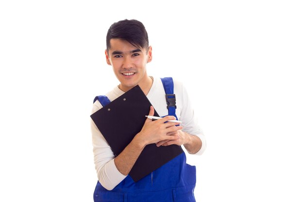 Giovane uomo felice con i capelli scuri che indossa una camicia bianca e una scritta blu in una cartella nera