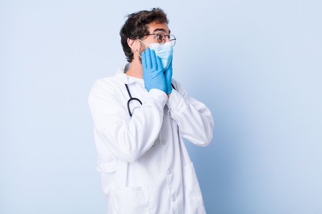 Giovane uomo felice, eccitato e sorpreso, guardando di lato con entrambe le mani sul viso. concetto di coronavirus