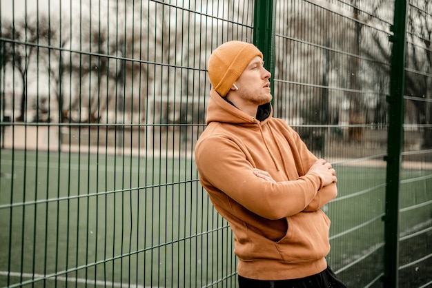 Giovane uomo in abito sportivo facendo allenamento mattutino all'aperto