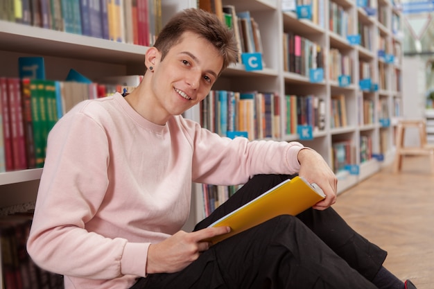 Giovane uomo in biblioteca o libreria