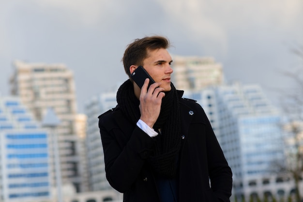 Giovane uomo in strada con il telefono cellulare