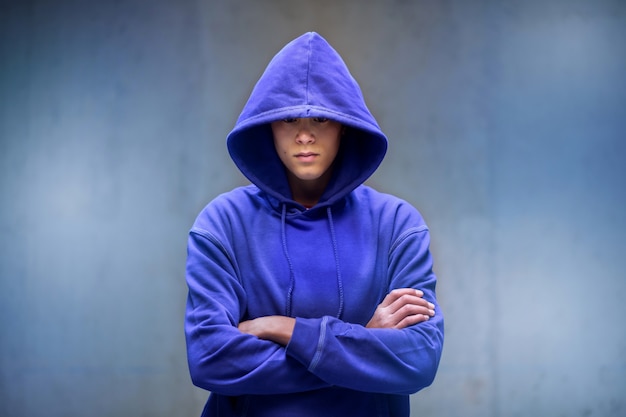 Giovane uomo in top blu con cappuccio abbassato