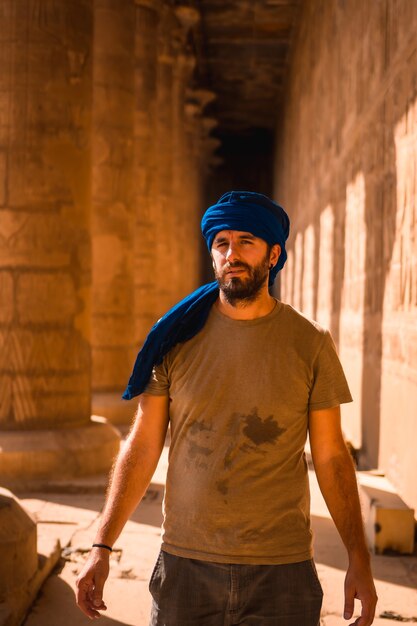 Giovane uomo in turbante blu che visita il Tempio di Edfu e le sue bellissime colonne vicino alla città di Assuan. Egitto