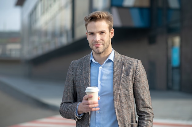 Giovane uomo in una camicia blu che sembra buona condizione accanto al centro commerciale