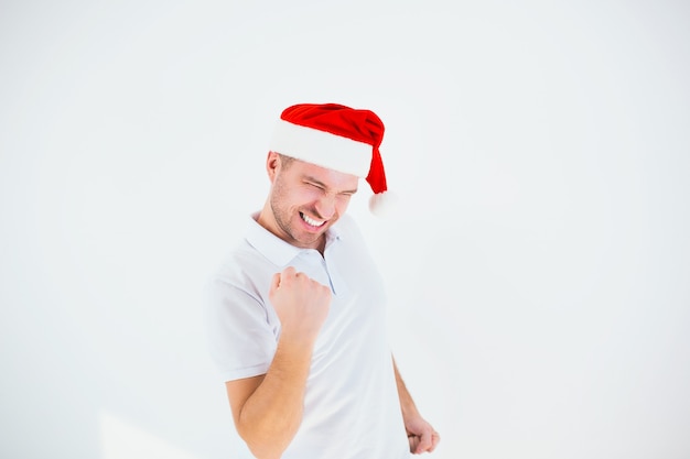 Giovane uomo in una maglietta bianca con un cappello di Babbo Natale