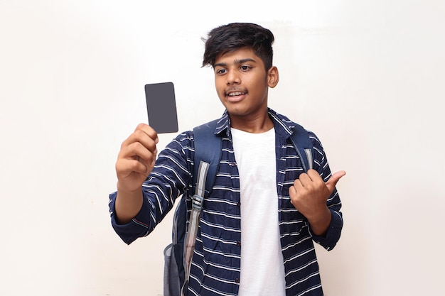 Giovane uomo indiano che mostra carta di debito o di credito su sfondo bianco