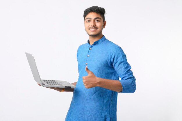 Giovane uomo indiano che utilizza laptop su sfondo bianco.