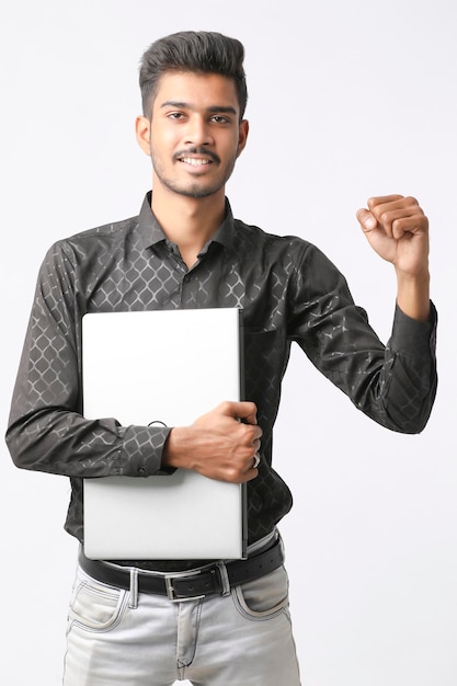 Giovane uomo indiano con laptop in mano su sfondo bianco.