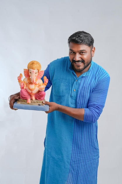 Giovane uomo indiano con Lord Ganesha che celebra il festival di Ganesha