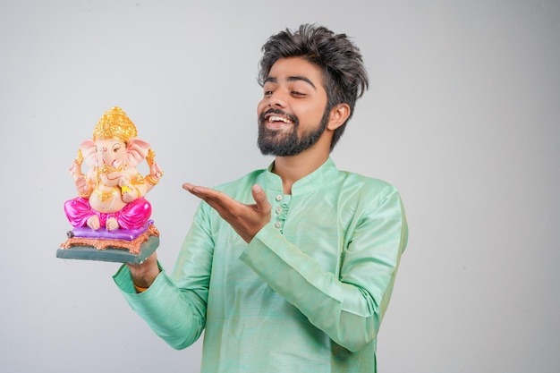 Giovane uomo indiano con Lord Ganesha che celebra il festival di Ganesha