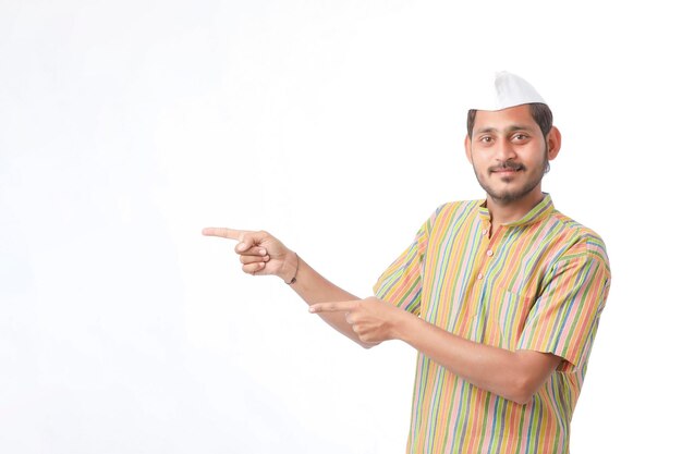 Giovane uomo indiano in abbigliamento tradizionale e che mostra la direzione su sfondo bianco