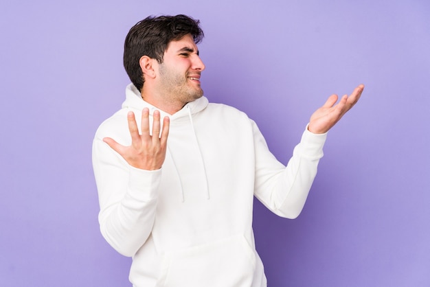 Giovane uomo isolato sul muro viola gioioso ridendo molto. Concetto di felicità.