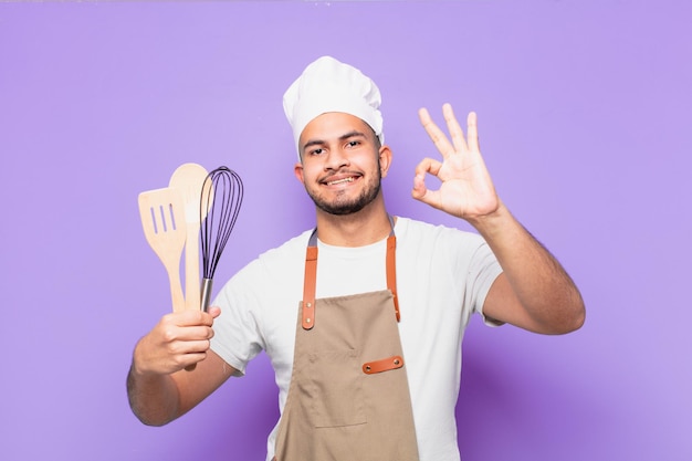 Giovane uomo ispanico espressione felice panettiere o concetto di chef