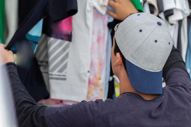Giovane uomo latino che indossa un berretto giovanile per la spesa di vestiti
