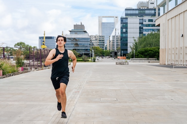 Giovane uomo latino che pareggia e corre. Concetto di vita sana.