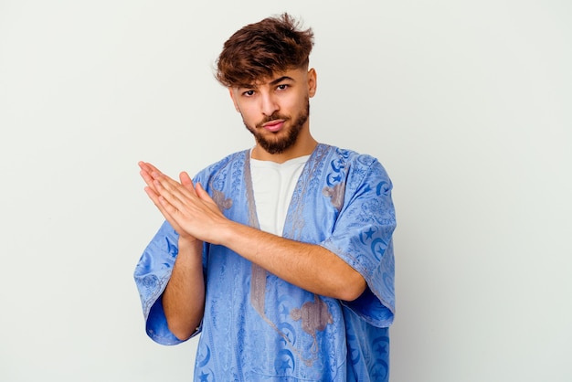Giovane uomo marocchino isolato su bianco sentirsi energico e confortevole, strofinando le mani fiducioso.