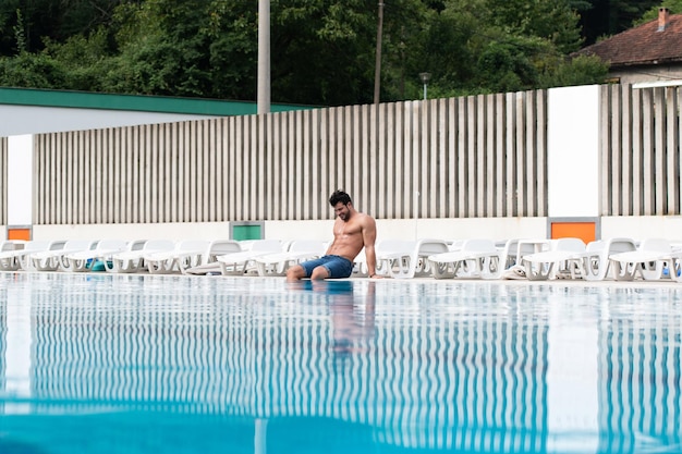 Giovane Uomo Muscolare Alla Piscina All'aperto