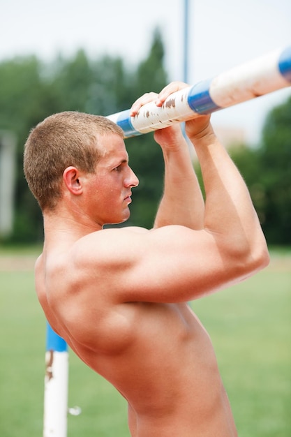 giovane uomo muscolare che fa pull-up