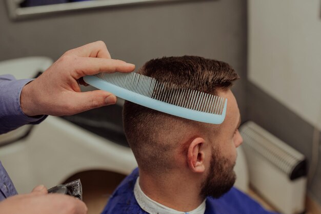 Giovane uomo nel concetto di servizio di cura dei capelli del barbiereGiovane uomo nel concetto di servizio di cura dei capelli del barbiere