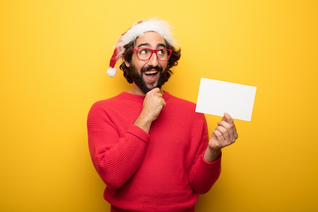 Giovane uomo pazzo barbuto che indossa occhiali rossi e cappello di Babbo Natale