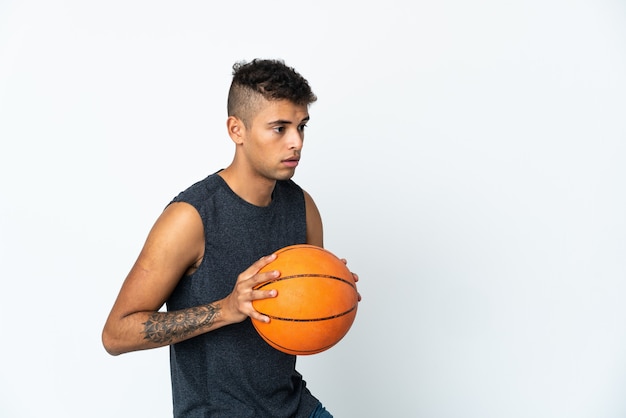 Giovane uomo sopra isolato giocando a basket