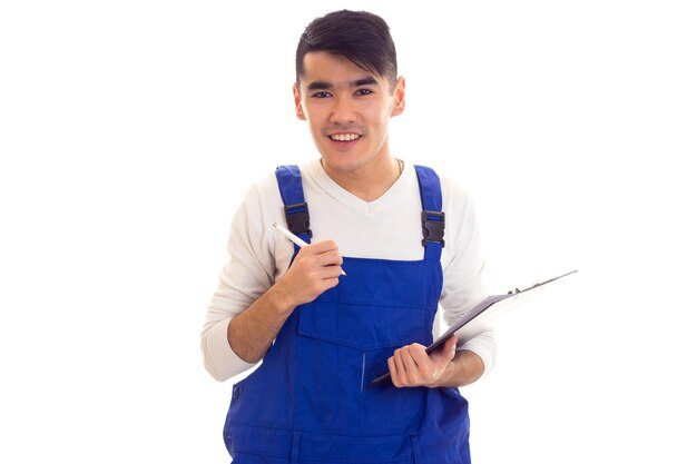 Giovane uomo sorridente con i capelli scuri che indossa una camicia bianca e una scritta blu in una cartella nera