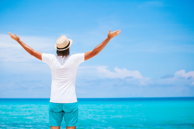 Giovane uomo sulla spiaggia bianca in vacanza