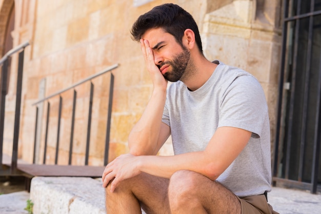 Giovane uomo triste in strada