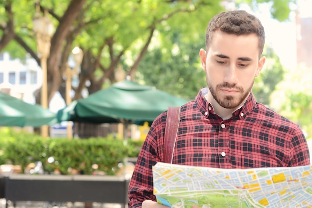 Giovane uomo turistico guardando una mappa.